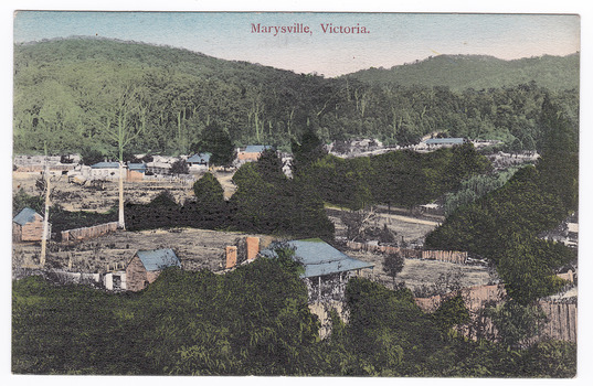 Shows the early Marysville township in Victoria. It shows various wooden buildings some of which are surrounded by wooden fences. In the background are forested mountains. The sky is tinted blue at the top and pink towards the hills. On the reverse of the postcard is space to write a message and an address and to place a stamp. The postcard is unused.