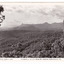 Shows a view of the range of mountains known as the Cathedral Range including Mount Cathedral. In the foreground are a series of heavily forested hills. On the reverse of the postcard is space to write a message and an address and to place a postage stamp. The postcard is unused.