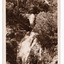Shows Steavenson Falls in Marysville in Victoria. Shows the waterfalls cascading down the mountain surrounded by the forest. On the reverse of the postcard is a space to write a message and an address and to place a postage stamp. The postcard is unused.