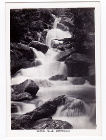 Shows Keppel Falls which is accesible from Lady Talbot Drive. Shows the falls cascading over large rocks through the forest. The title of the photograph is along the lower edge of the photograph.