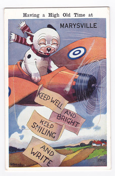 Shows an illustration of a black and white dog with a striped scarf around its neck sitting in an aircraft that is flying over a house in some fields. The dog has released some pieces of paper which read 'KEEP WELL, AND BRIGHT, KEEP SMILING, AND WRITE'. The title of the postcard is across the top edge. There is a lift-up flap in the middle with a pull-out strip of 9 miniature photographs of places of interest in and around Marysville. On the reverse of the postcard is a hand-written message.