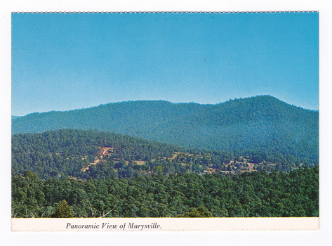 Shows the view of Marysville from Barton's Lookout which is near the Cumberland Valley in Victoria. Shows the town surrounded by heavily forested mountains. On the reverse of the postcard is a space to write a message and an address and to place a postage stamp. The postcard is unused.