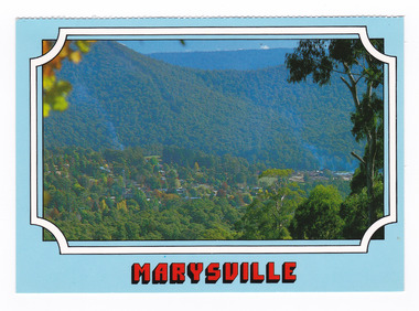 Shows the view of Marysville in Victoria from Cumberland lookout. Shows the town surrounded by heavily forested mountains. On the reverse of the postcard is a space to write a message and an address and to place a postage stamp. The postcard is unused.