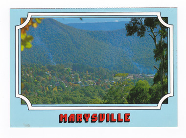  Shows the view of Marysville in Victoria from Cumberland lookout. Shows the town surrounded by heavily forested mountains. On the reverse of the postcard is a space to write a message and an address and to place a postage stamp. The postcard is unused.