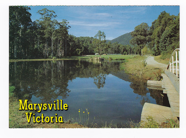 Shows Darmody's Lake in Marysville in Victoria. Shows the lake surrounded by forest and forested mountains. On the reverse of the postcard is a space to write a message and an address and to place a postage stamp. The postcard is unused.