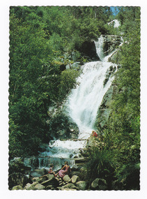  Shows Steavenson Falls in Marysville in Victoria. Shows the falls cascading down the mountain surrounded by forest. At the base of the falls there are a woman and a child sitting on sme large rocks. On the reverse of the postcard is a space to write a message and an address and to place a postage stamp. The postcard is unused.