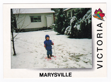 Shows a child skiing in snow somewhere in Marysville in Victoria. In the background are two weatherboard buildings. On the reverse of the postcard is a space to write a message and an address and to place a postage stamp. The postcard is unused.
