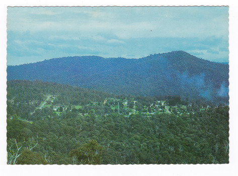 Shows the view of Marysville from the Cumberland Range. Shows Marysville surrounded by heavily forested mountains. On the reverse of the postcard is a hand-written message.