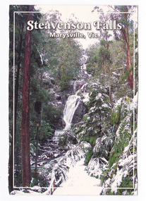 A colour photograph of Steavenson Falls in Marysville in Victoria during the winter. The track leading to the base of the falls is covered in snow as are the surrounding forest. On the reverse of the postcard is a space to write a message and an address and to place a postage stamp. The postcard is unused.