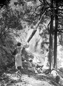 Shows three women sitting and standing on a path that leads to the Steavenson Falls in Marysville in Victoria.