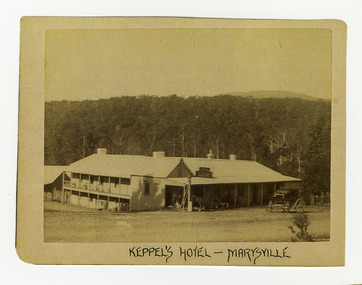 Shows the Keppels Australian Hotel in Marysville in Victoria. Standing out the front of the hotel is a horse-drawn coach and there is a horse standing under the front verandah of the hotel. Also standing under the verandah can be seen three women. In the background is the forest and the top of a mountain can be seen above the forest. The title of the photograph is along the lower edge in black ink. On the reverse of the photograph is a stamp from the Armstrong Collection at 42 Station Street in Sandringham in Victoria.