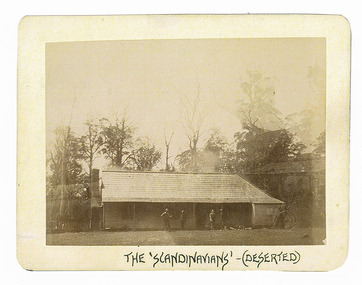 Shows The Scandinavians' which was a hotel and boarding house along the Yarra Track. Shows a timber clad building with a timber shingled roof. At the right of the building is a brick chimney and at the left of the building is a jinker. There are four men standing in front of the building. The title of the photograph is along the lower edge in black ink. On the reverse of the photograph is a stamp from the Armstrong Collection at 42 Station Street in Sandringham in Victoria.