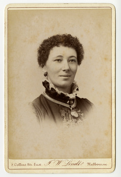 A black and white portrait of an unknown woman taken by John William Lindt. Reverse shows location of John Lindt's studio, his special publications and his various awards and diplomas and the places he won them. Shows also a view of Melbourne, taken by John LIndt.