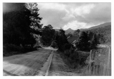 Shows the view down Lyell Street towards Murchison Street in Marysville in Victoria. In the background can be seen some mountains.