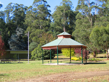 Shows the rotunda in Lions' Park in Marysville in Victoria. In the background can be seen the Marysville Bowling Club building.