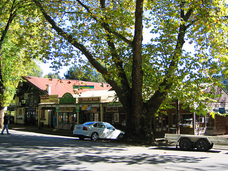 Shows Murchison Street in Marysville in Victoria. Shows a row of shops with one car parked outside them. There is also one person crossing the street.