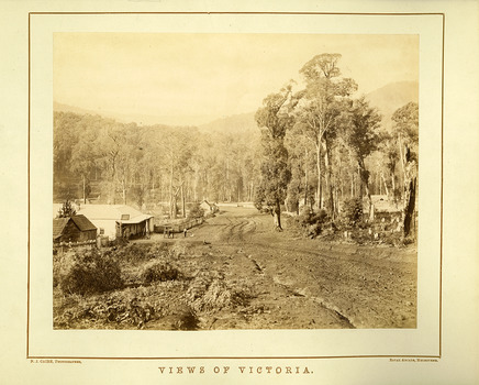 Shows the main road in Marysville in Victoria. In the left of the photograph is the Keppel's Australian Hotel with two men and a horse-drawn dray standing outside. Across the road is another building with another down the road.