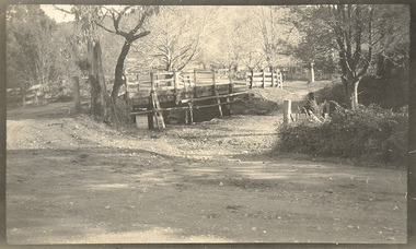 Shows a wooden bridge crossing a river in Marysville in Victoria.
