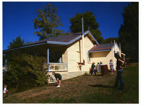 Shows a cream weatherboard house that was positioned in Sedgwick Street in Marysville in Victoria. Shows a lady and four children of various ages standing outside the house.