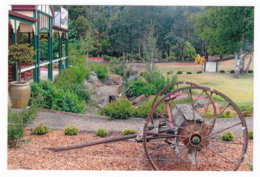 Shows the front verandah of the Marysville Patisserie in Marysville in Victoria. Shows the front garden with an old seeder in the front garden.