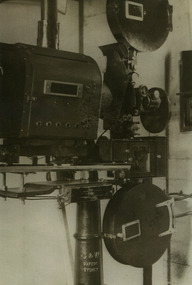 Shows a black and white photograph of one of the projectors for the Marysville Theatre.