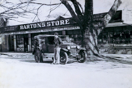 Shows Barton's Store in Marysville in Victoria. Shows that they were butchers and bakers and the variety of goods and services that were available from the store. In front of the store is an early model car with two men standing next to the car.