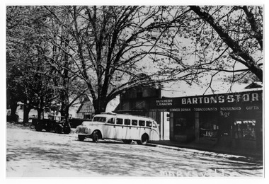 Shows Barton's Store in Marysville in Victoria. Shows that they were butchers and bakers and the variety of goods and services that were available from the store. In front of the store is an early bus. Next to the store is the picture theatre and Barton's Garage. Also shows an early model jeep with other cars parked outside the Barton's Garage.