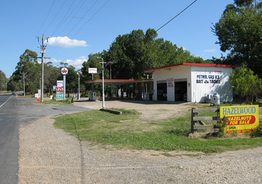 Shows Choppers Buxton Road House in Buxton in Victoria. Shows the outside of the building with the petrol bowsers and the signs showing the price of fuel. Shows a Caltex advertising sign. On the side of the building is a sign advertising petrol, gas, ice, bait and tackle.