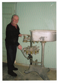 Shows Tino Gianforte with a milk bottle machine in the Marysville Dairy.