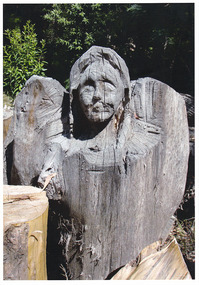 Shows a chainsaw sculpture of the head and wings of an angel.