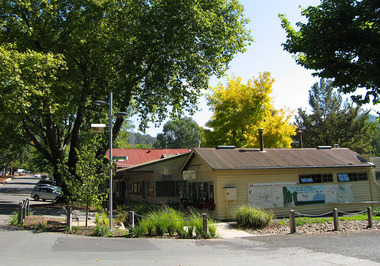 Shows The Corner Cupboard Cafe. Along the side of the building a painted map of Marysville and the surrounds. Also shows the view looking up Murchison Street.