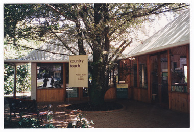 Shows the front facade of Country Touch in Marysville in Victoria. Shows a timber building with a corregated iron roof. Shows a sign with the name of the shop along with Pottery Studio and Gallery.