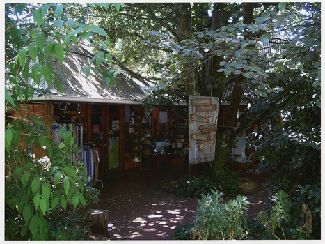 Shows the front facade of Country Touch in Marysville in Victoria. Shows various items for sale displayed around the front entry to the shop. Shows a sign made from corregated iron with wooden signs with the goods and services available in the shop.