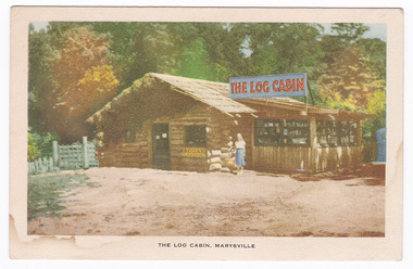 Shows the front facade of The Log Cabin in Marysville in Victoria. Shows a lady standing in front of the shop.