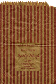 Shows a paper bag from Uncle Fred & Aunty Val's Old Style Lolly Shop in Marysville in Victoria. The bag is striped with red with the name, address and the telephone number of the shop on the front.