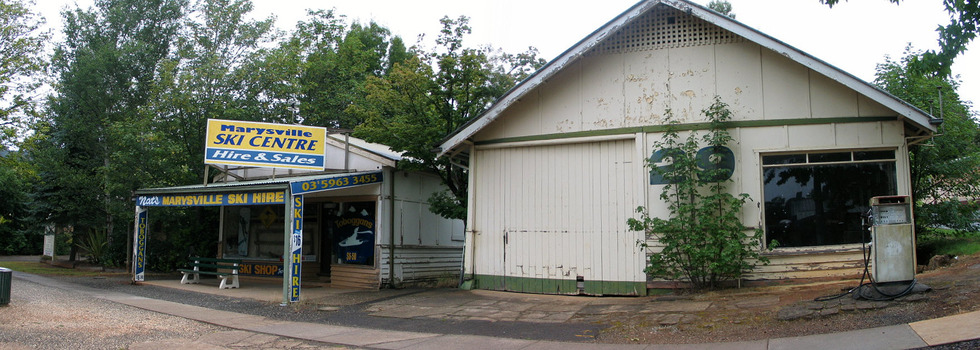 Shows the front facade of the Marysville Ski Centre in Victoria. Shows a building with advertising signs attached to the roof and verandah.