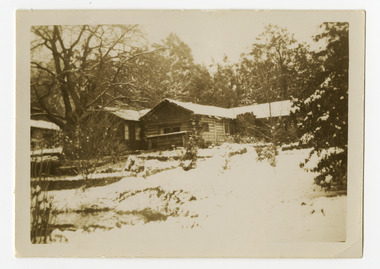 Shows The Log Cabin in Marysville in Victoria. Shows the building and its gardens covered with a heavy snowfall.