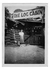 Shows a lady standing outside The Log Cabin in Marysville in Victoria.