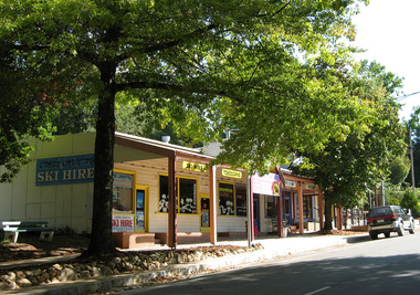 Shows the front facade of Cross Country Ski Hire in Marysville in Victoria. Shows advertising signs of various items and services available at the shop.