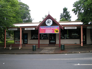 Shows the front facade of Cross Country Ski Hire in Marysville in Victoria. Shows advertising signs of goods and services that are available at the shop.