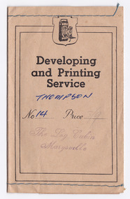 Shows an envelope that was used to present photographs or negatives after they were developed and printed. Envelope has blue stitching along both upper and lower edges.