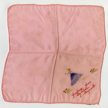 Shows a pink handkerchief with a hand painted crinoline lady holding a flower in one corner. Shows the words "Greetings from Log Cabin, Marysville". in red hand painted letters.