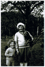 Shows members of the Branchflower Family in Marysville in Victoria. Shows a young girl who is holding a dog under her left arm and who is holding the hand of a young boy.