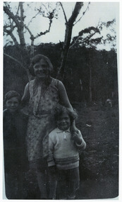 Shows members of the Branchflower Family in Marysville in Victoria. Shows a woman standing with two young boys.
