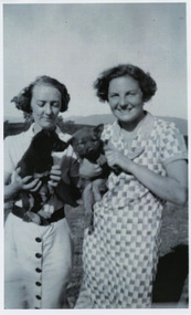 Shows members of the Branchflower Family in Marysville in Victoria. Shows two women holding a puppy each.