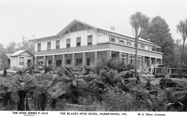 Shows a photograph of the Blacks Spur Hotel in Narbethong. Shows a large double storey building with a verandah along the front of both floors. Shows a car standing at the entrance to the hotel.