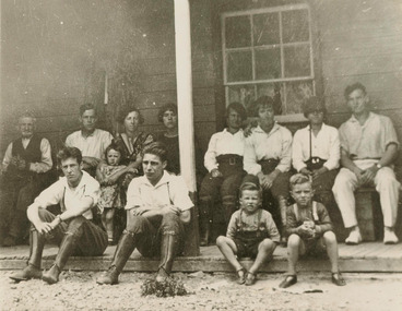 Shows a black and white photograph of members of the Burchall Family on the verandah of the Cathedral-Side Hotel in Taggerty.