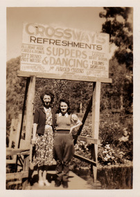 A black and white photograph of two unknown ladies standing under the sign at The Crossways in Marysville.