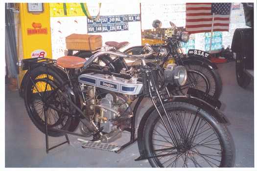 Shows two motorbikes that were housed in The Marysville Museum in Marysville in Victoria. Shows a Douglas motorbike and a B.S.A. motorbike.