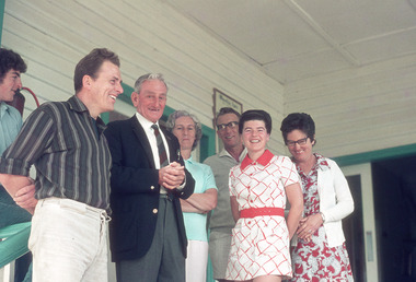 A digital copy of a colour photograph of a group of people standing on the front verandah at Mountain Lodge in 1974.